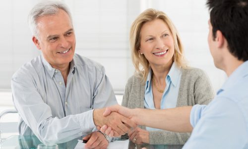 19339638 - senior happy couple shaking hand with financial advisor
